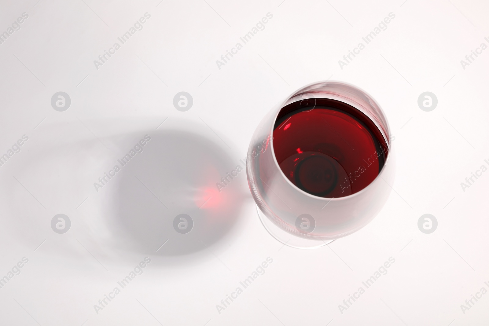 Photo of Tasty red wine in glass isolated on white, above view