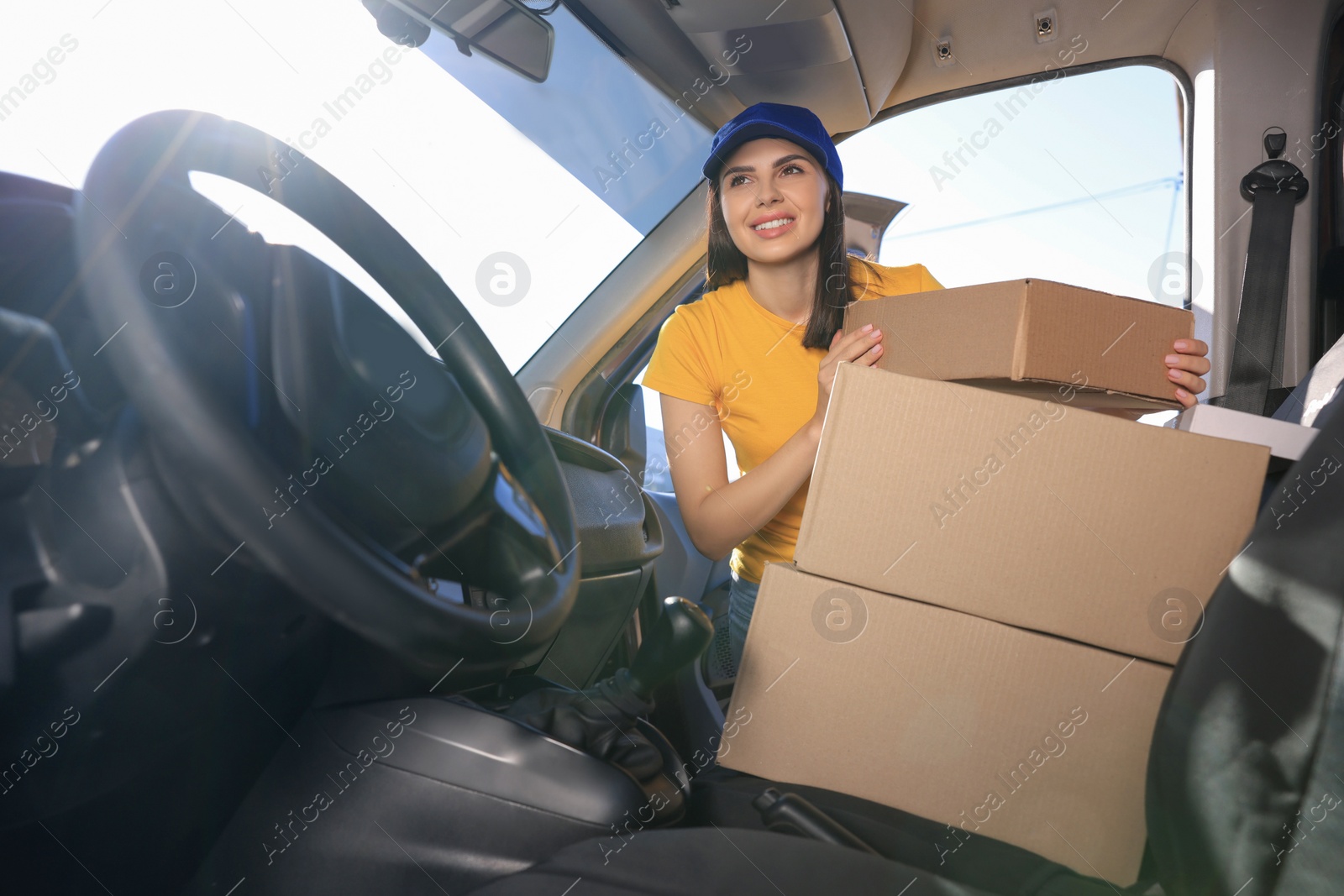 Photo of Courier taking parcel from car. Delivery service