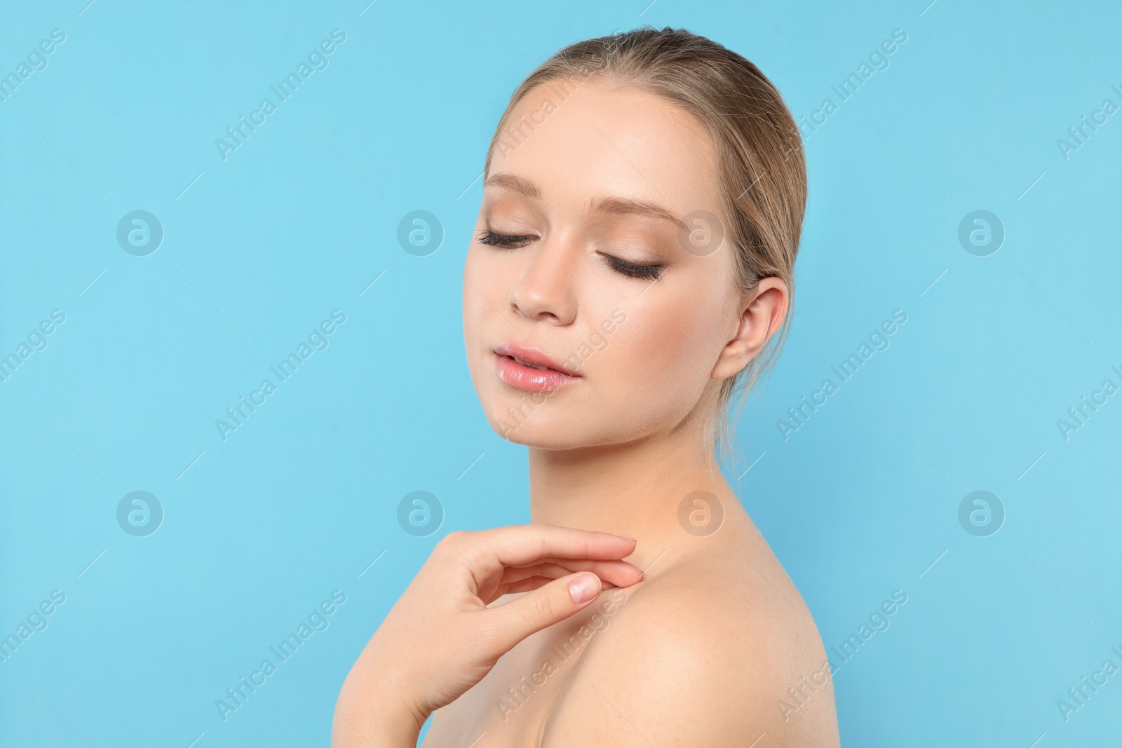 Photo of Portrait of young woman with beautiful face on blue background