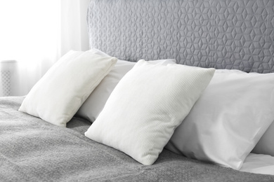 Photo of Bed with soft fluffy pillows at home