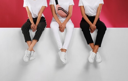 Photo of Women wearing stylish shoes on color background, closeup