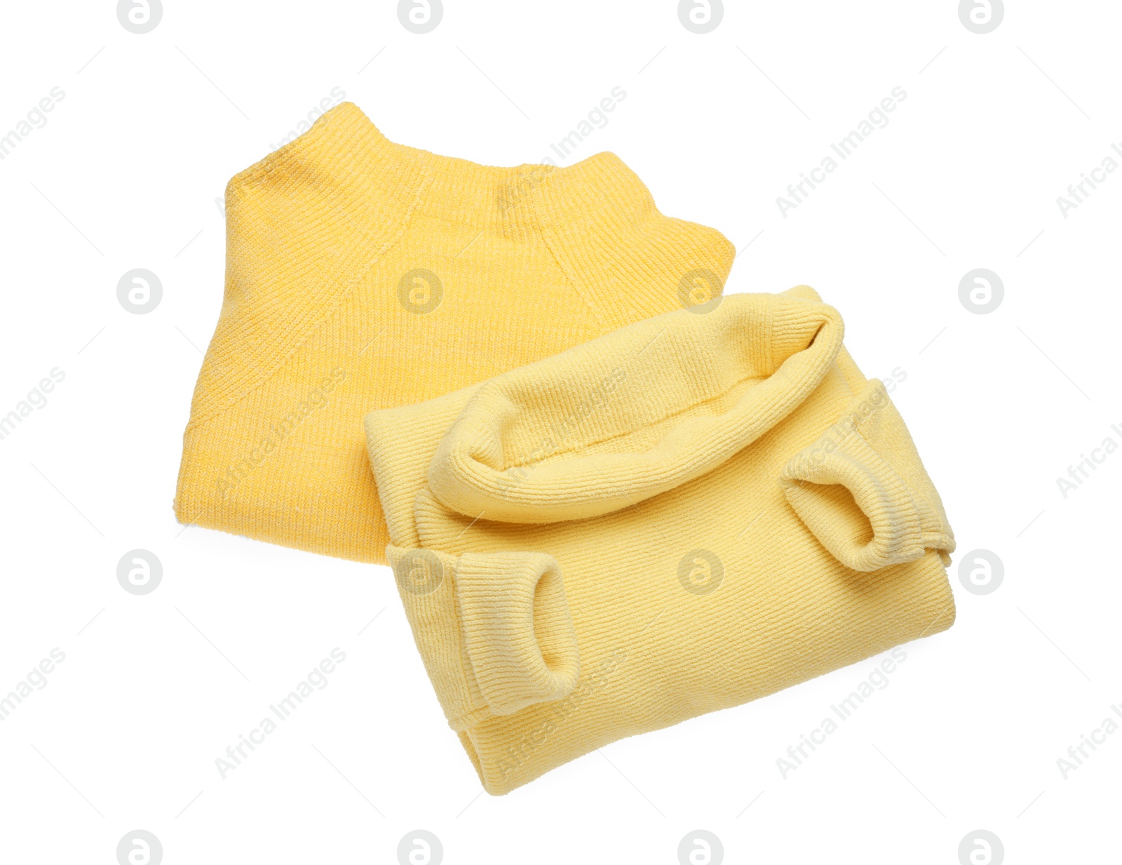 Photo of Yellow woolen sweaters on white background, top view