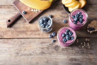 Flat lay composition with blueberry smoothies on wooden background