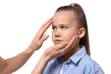 Photo of Mother applying ointment on her daughter's forehead against white background