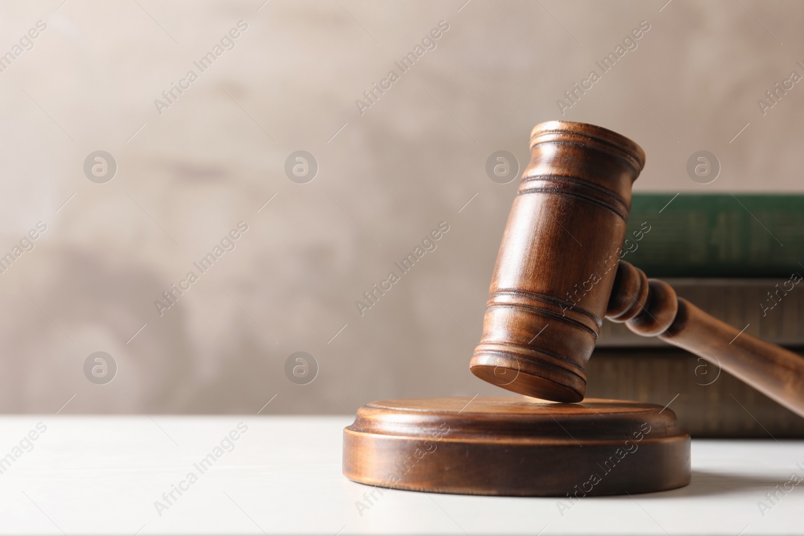 Photo of Wooden gavel and books on table against color background. Law concept