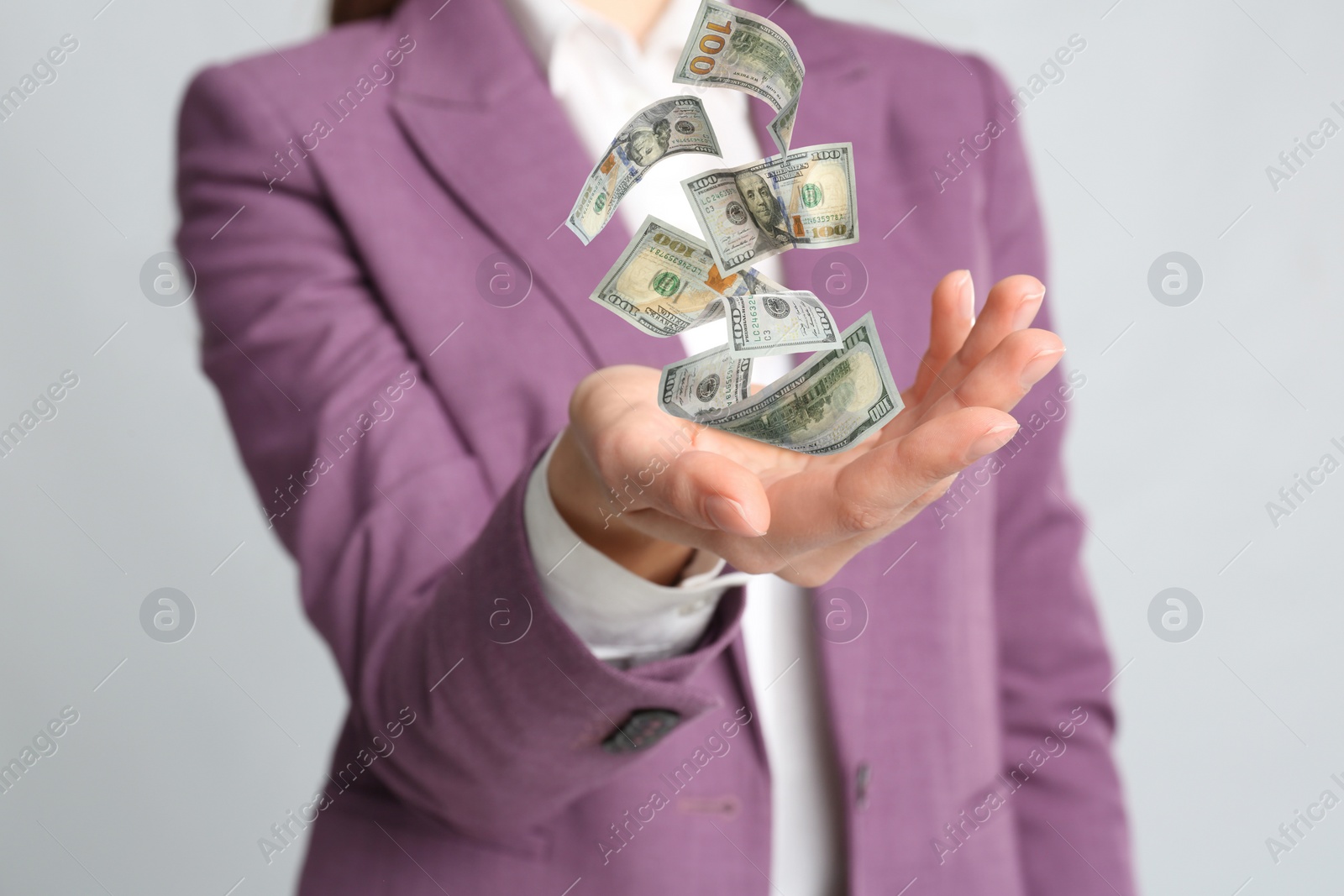 Image of Woman with money on light grey background, closeup. Currency exchange