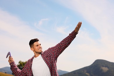 Photo of Man throwing boomerang in mountains on sunny day