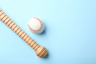 Baseball glove, bat and ball on pale light blue background, flat lay. Space for text