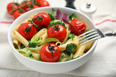 Photo of Bowl of delicious pasta with tomatoes, arugula and broccoli on white table, closeup