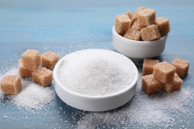 Different types of sugar on light blue wooden table
