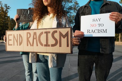 Photo of Group of people holding signs outdoors, closeup. Racism concept
