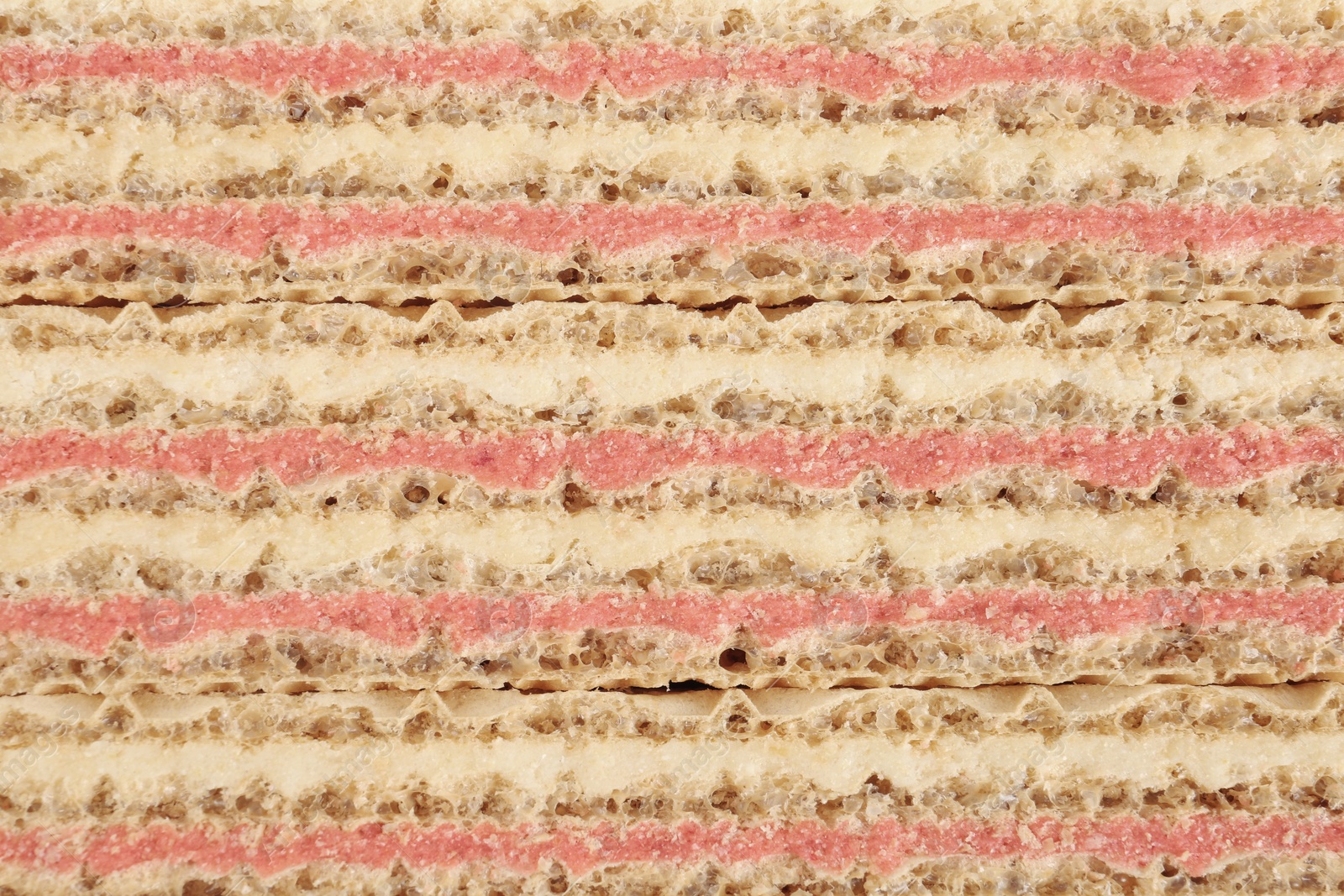 Photo of Wafer sticks with pink filling as background, closeup. Sweet food