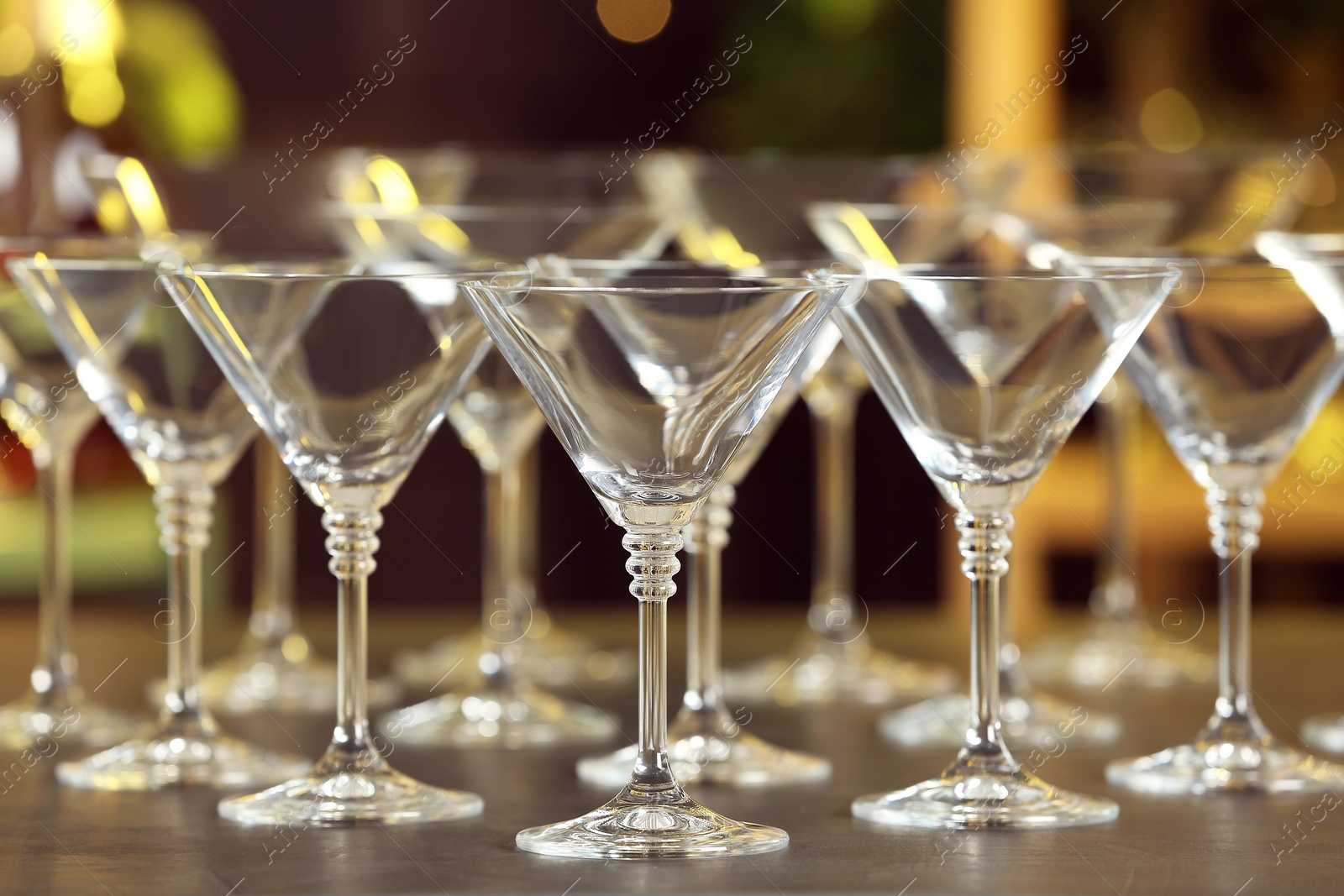 Photo of Empty martini glasses on table against blurred background