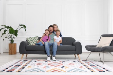 Portrait of happy family with children on sofa at home