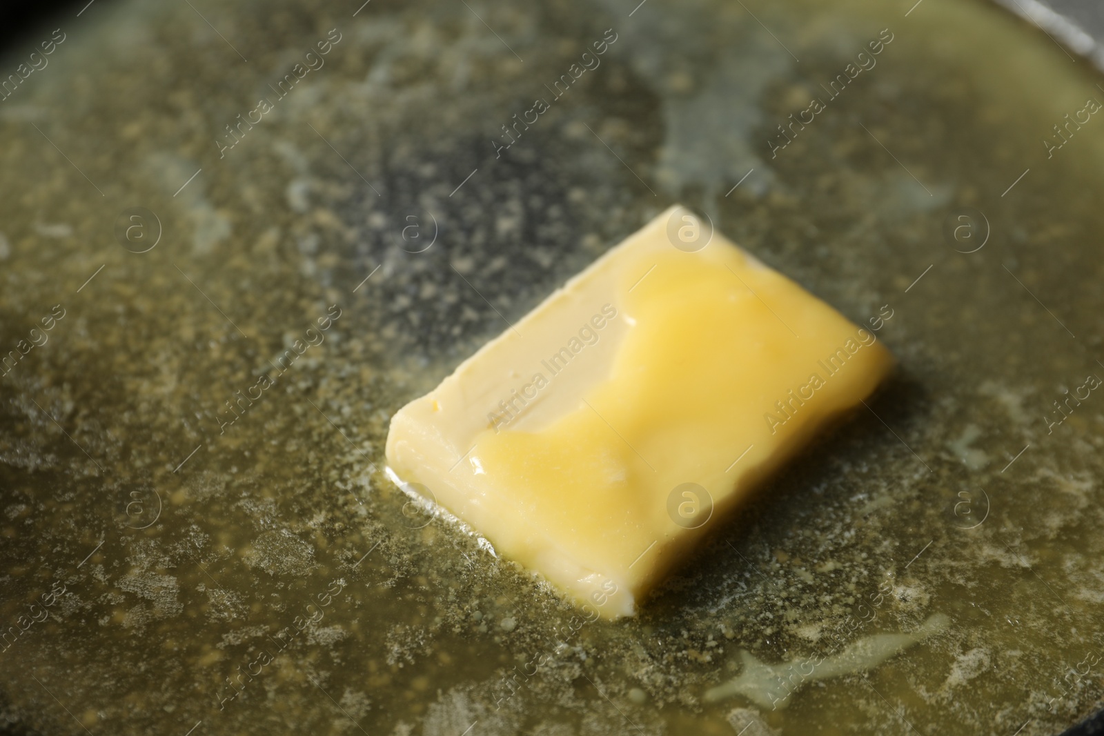 Photo of Melting butter in frying pan, closeup view