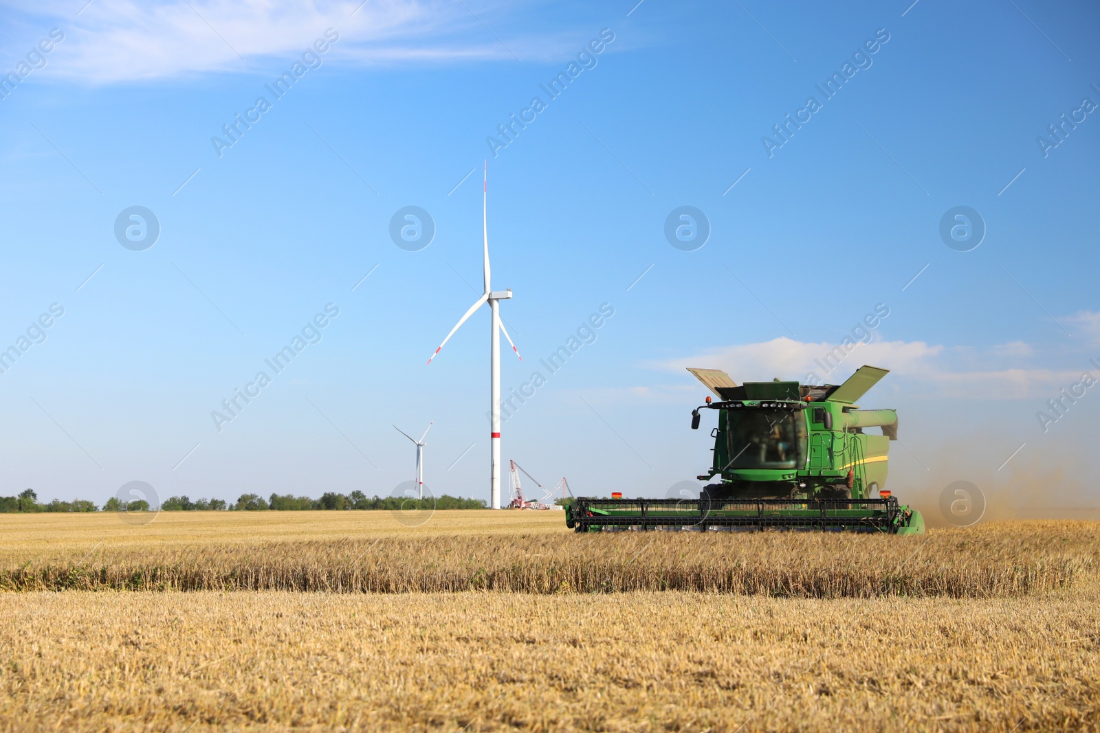 Photo of Modern combine harvester working in agricultural field