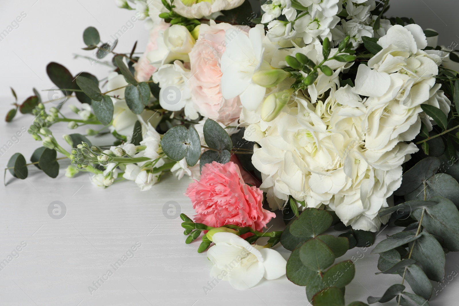 Photo of Bouquet of beautiful flowers on white wooden table, closeup