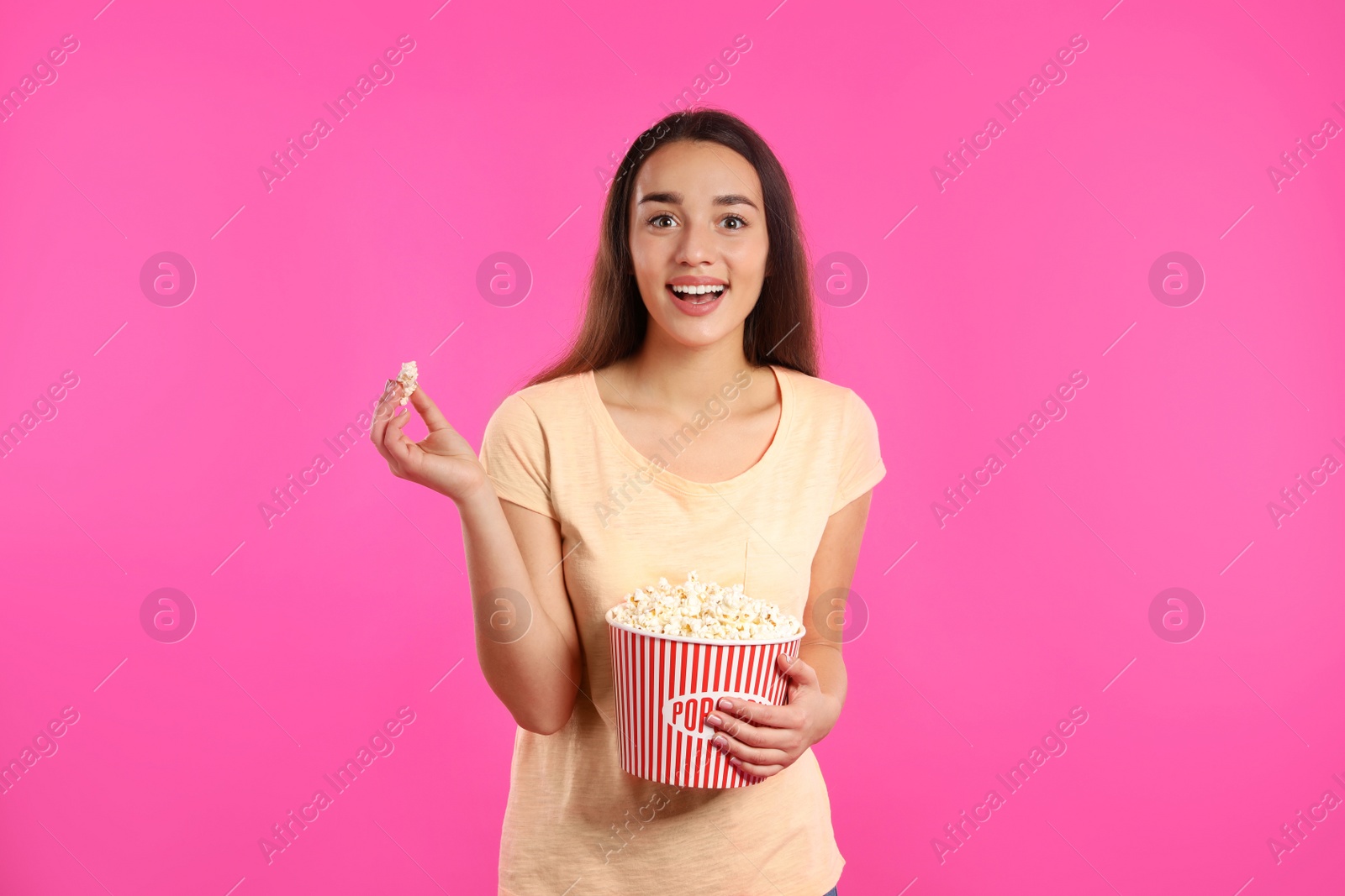 Photo of Woman with popcorn during cinema show on color background