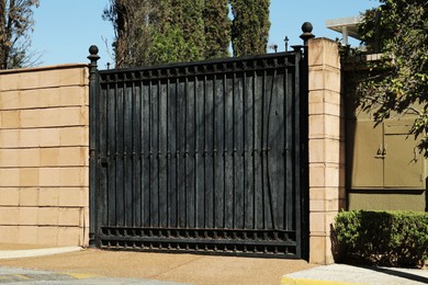 Closed security metal gates near trees outdoors