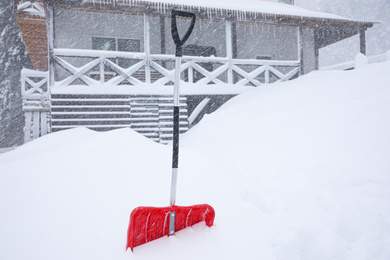 Snow cleaning shovel near house. Winter outdoor work