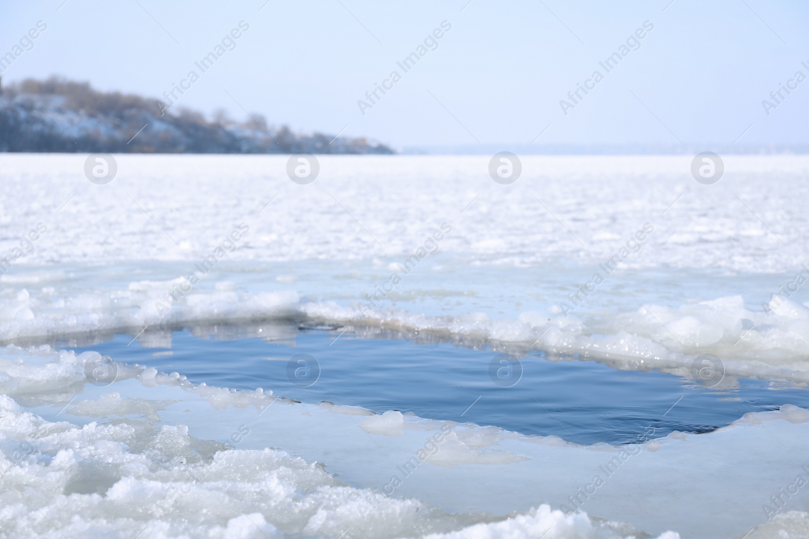 Photo of Ice hole in river on winter day. Baptism ritual