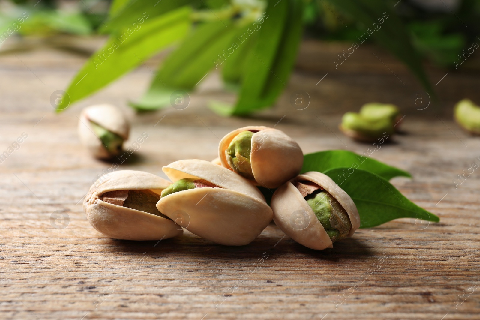 Photo of Organic pistachio nuts in shell on wooden table