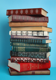 Stack of hardcover books on light blue background