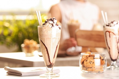 Photo of Glass with delicious milk shake on table indoors