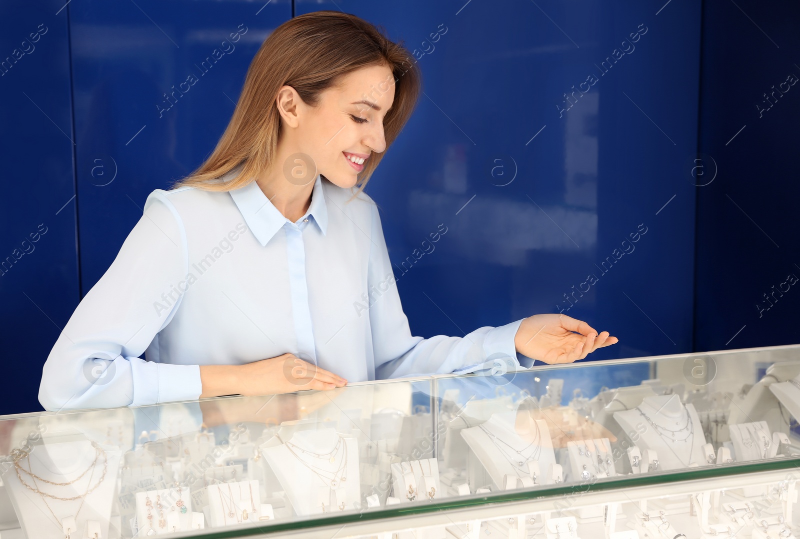 Photo of Portrait of young saleswoman near showcase in jewelry store