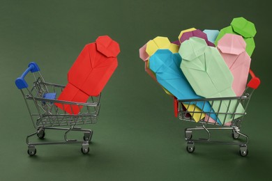 Recruitment process, job competition concept. Composition with paper human figures and toy shopping carts on green background