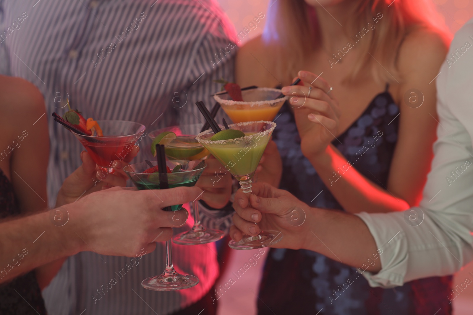 Photo of Group of young people holding martini cocktails at party, closeup