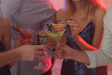 Photo of Group of young people holding martini cocktails at party, closeup