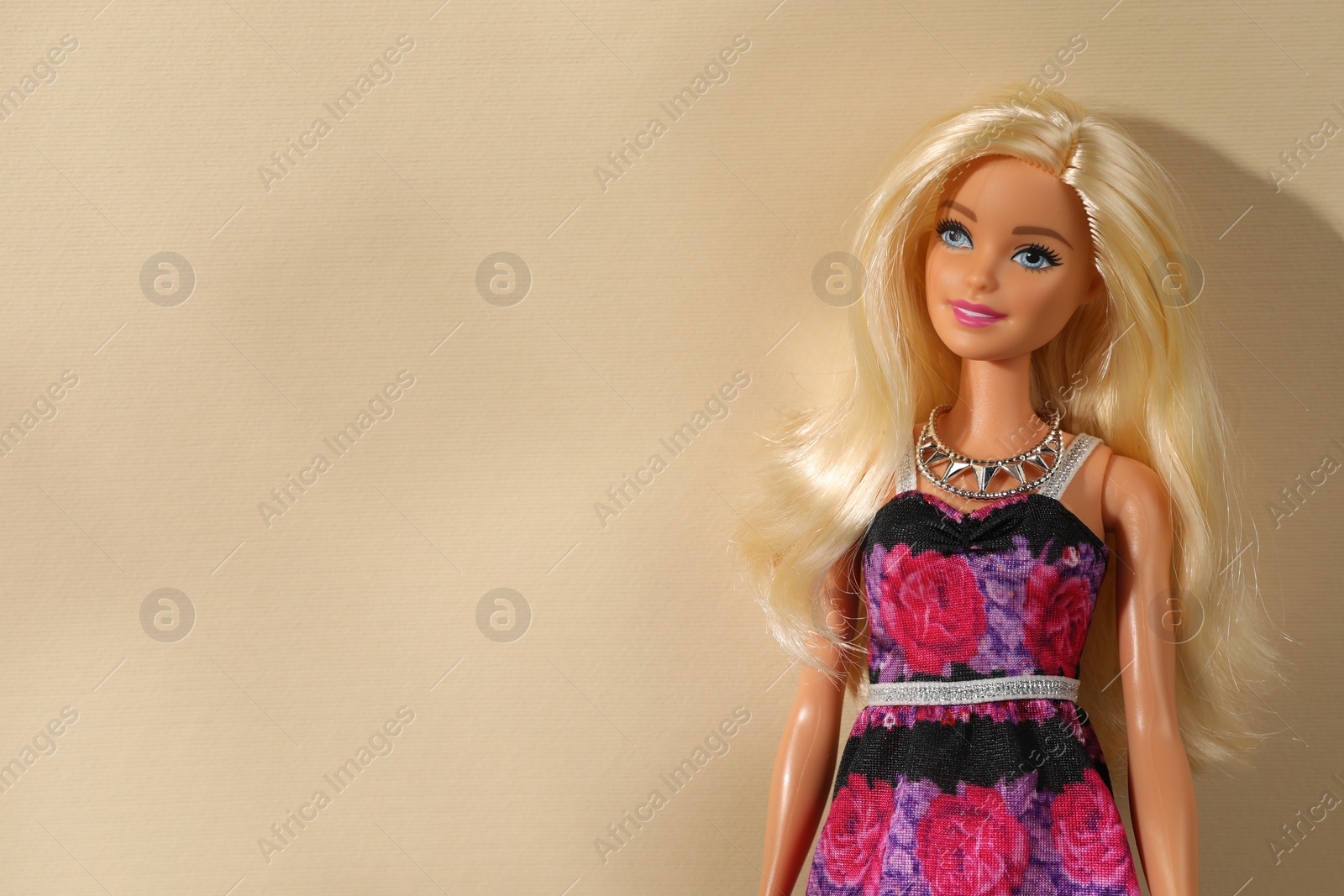 Photo of Mykolaiv, Ukraine - September 4, 2023: Beautiful Barbie doll wearing necklace on beige background, space for text