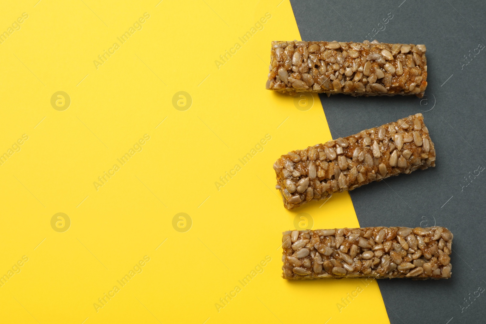 Photo of Delicious kozinaki bars on color background, flat lay. Space for text