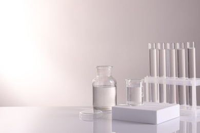 Laboratory analysis. Different glassware on table against light background, space for text