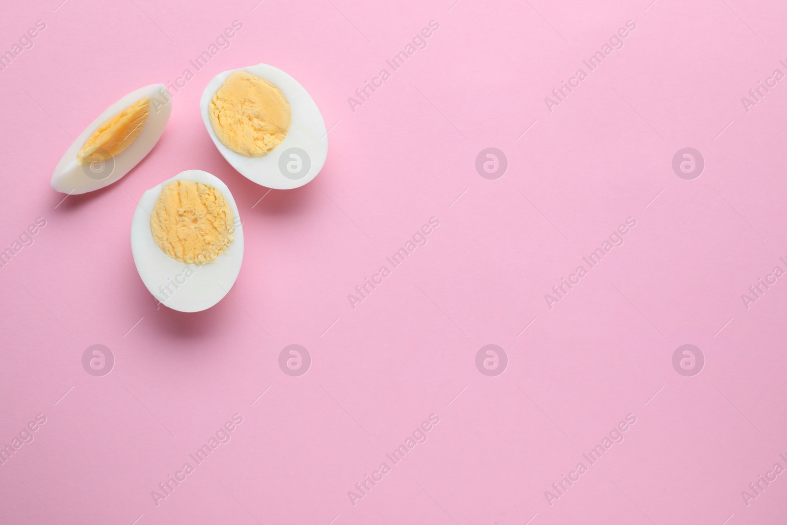 Photo of Fresh hard boiled eggs on pink background, flat lay. Space for text