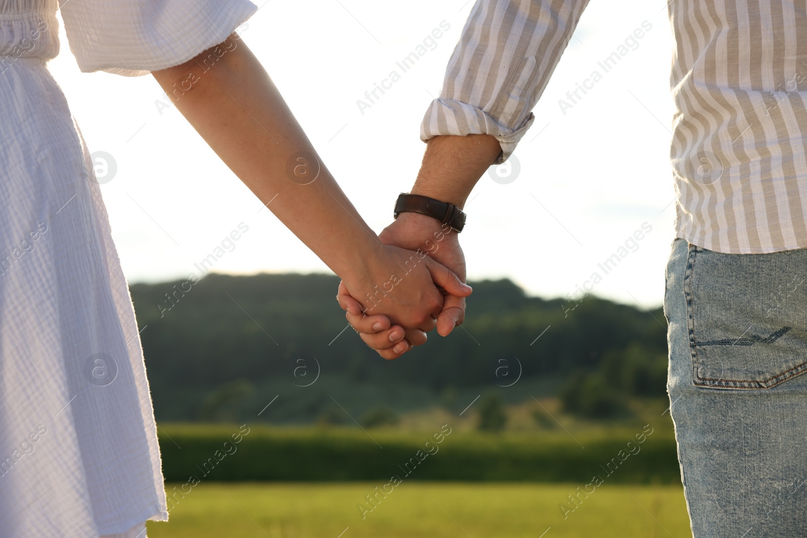 Photo of Romantic date. Couple holding hands outdoors, closeup