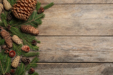 Photo of Flat lay composition with pinecones on wooden background, space for text