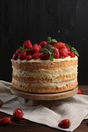 Tasty cake with fresh strawberries and mint on wooden table