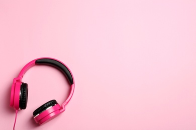 Stylish headphones on color background, top view. Space for text