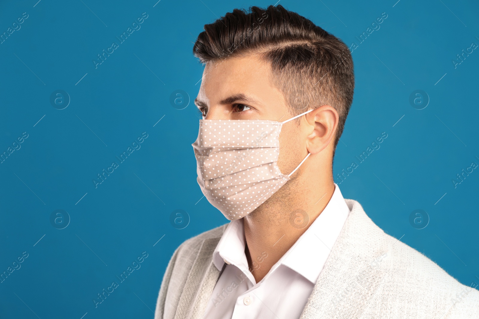 Photo of Man in protective face mask on blue background. Space for text