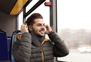 Photo of Young man with headphones in public transport