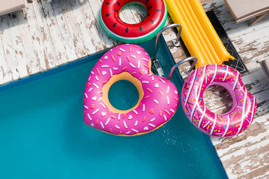 Image of Above view of inflatable rings and swimming pool. Summer vacation