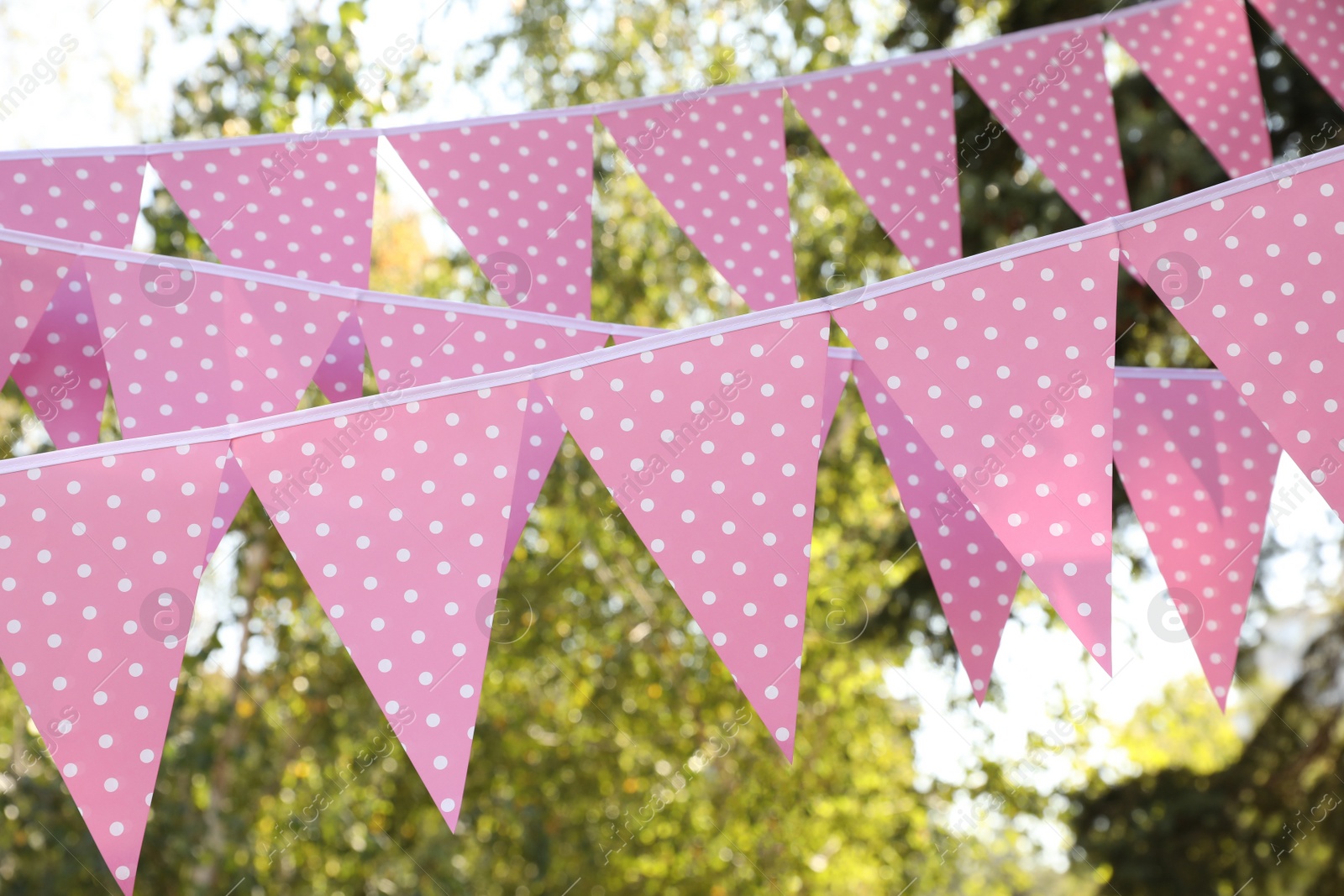 Photo of Pink bunting flags in park. Party decor