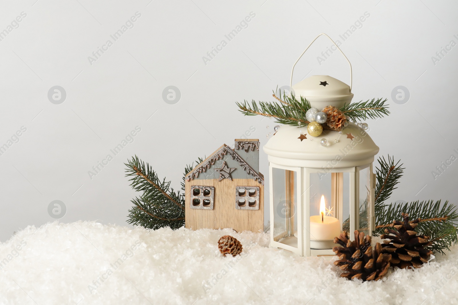 Photo of Beautiful composition with vintage Christmas lantern and festive decorations on snow against white background. Space for text