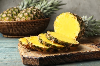 Photo of Board with cut fresh juicy pineapple on wooden table