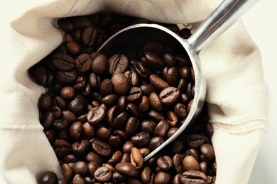 Photo of Bag with scoop and roasted coffee beans, closeup