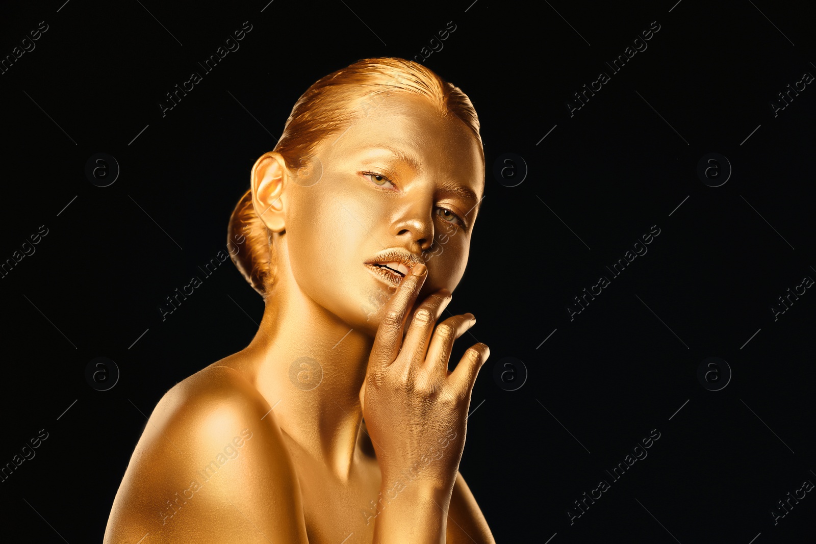 Photo of Portrait of beautiful lady with gold paint on skin against black background. Space for text