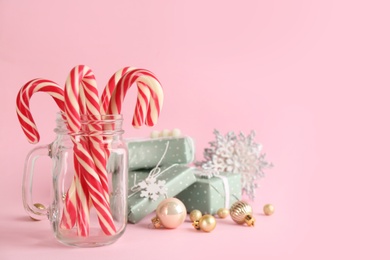 Photo of Candy canes, gift boxes and Christmas decor on pink background, space for text