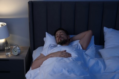 Photo of Handsome man sleeping in bed at night